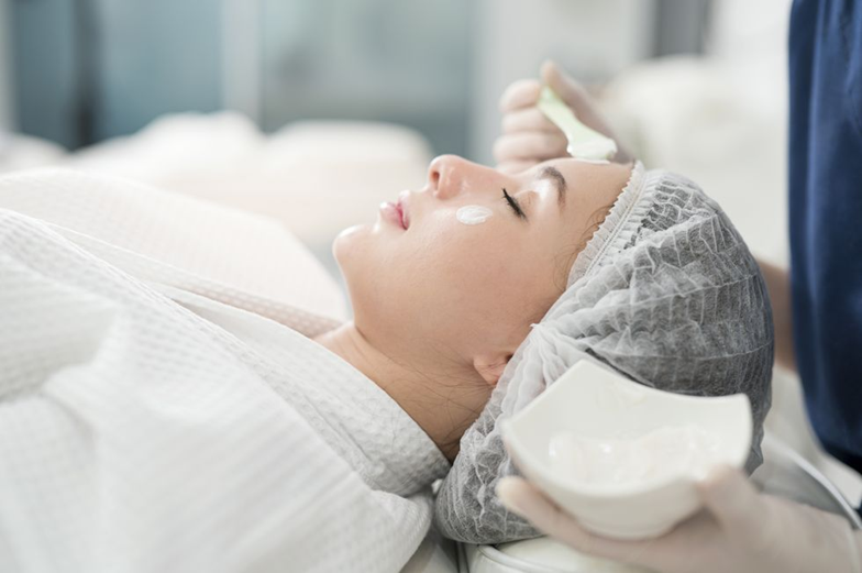 peeling-quimico-medico-revista-diez-minutos-doctora-trasmonte Mujer recibiendo un tratamiento facial médico estético de peeling químico en clínica por profesional en Madrid.