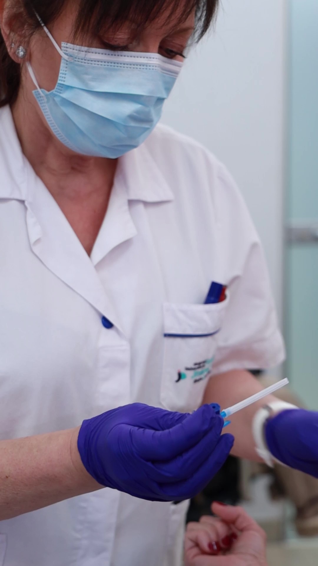 Personal sanitario preparando una sesión de sueroterapia de forma cuidadosa y personalizada en consulta médica.