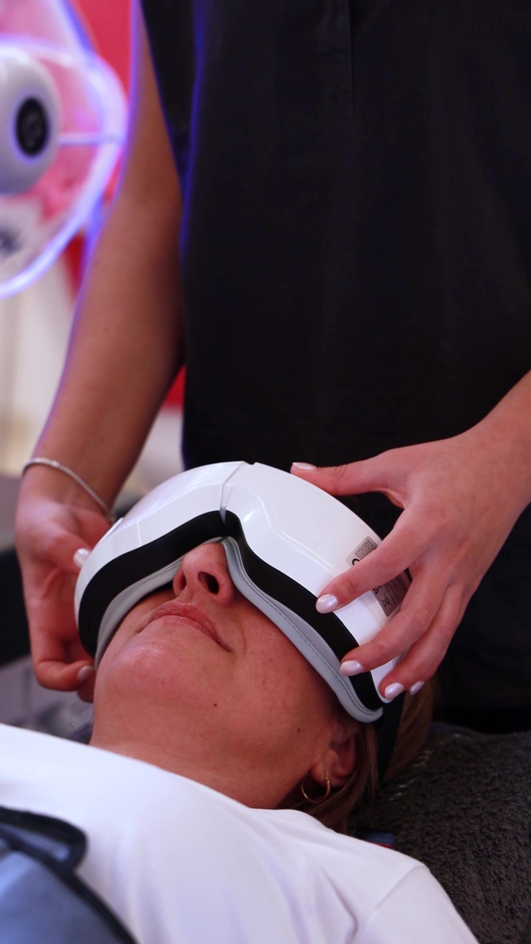 Paciente utilizando gafas de relax durante una sesión de sueroterapia, acompañada por personal sanitario en consulta médica.