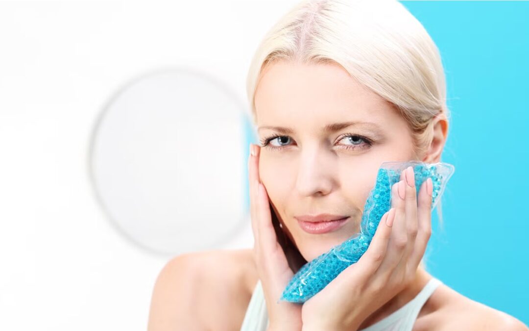 Mujer aplicando frío en el rostro para reducir la inflamación facial, imagen relacionada con retención de líquidos y cuidado de pómulos y mandíbula