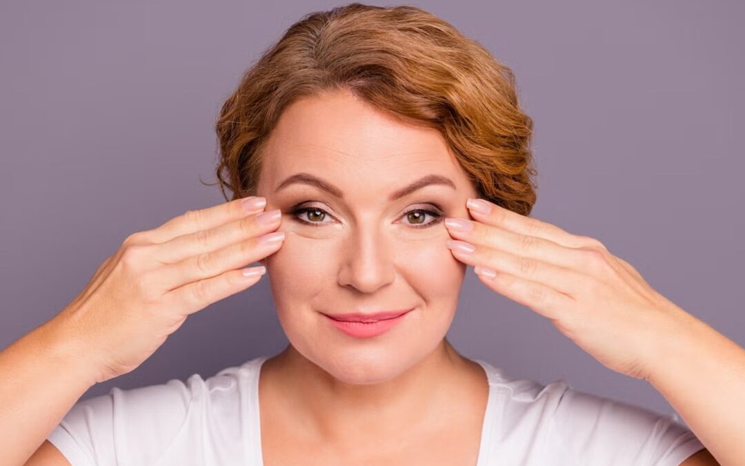Mujer tocando el rostro con piel luminosa, imagen relacionada con el efecto buena cara y tratamientos de medicina estética natural para mejorar la calidad de la piel