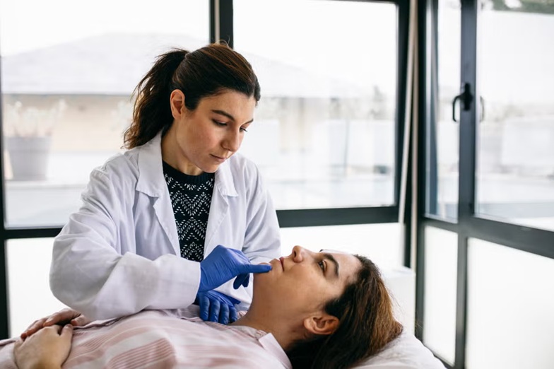 Médica realizando valoración facial en consulta de medicina estética, imagen relacionada con diagnóstico personalizado y planificación de tratamientos faciales naturales