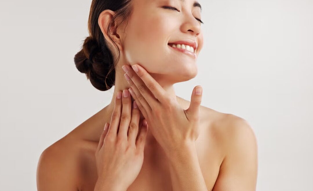 Mujer mostrando la piel del cuello, una zona que requiere cuidados y tratamientos específicos para prevenir y corregir el envejecimiento.