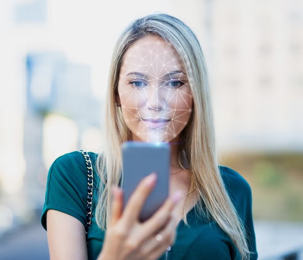 Mujer analiza su rostro con inteligencia artificial mediante un móvil, ilustrando el uso del reconocimiento facial y las simulaciones digitales en medicina estética.